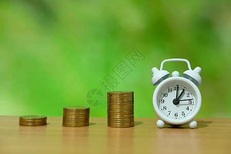 时间是金钱的概念  一堆钱 在木桌上有白钟办公室倒数储蓄成功市场硬币经济货币圆圈玻璃图片