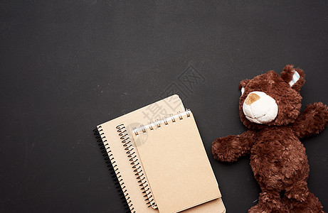 一叠带空白白纸和棕色泰迪熊的笔记本学习玩具桌子柔软度学校玻璃教育广告牌木板黑色图片