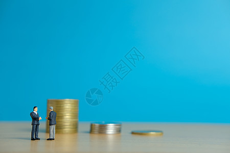 微型商业概念  两名商务人士在硬币堆前为合伙协议握手握手宝藏现金金融交易会议交换财富货币贷款合同图片