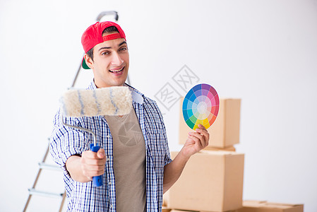 年轻画家承包商选择家庭翻新的颜色青年画家画笔绘画笔记本滚筒装修工人装潢房子男人梯子图片