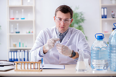 年轻化学学生在实验室做实验微生物器皿管子物质药品化学品玻璃男人助手医生图片