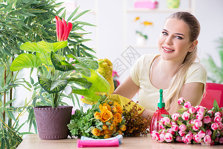 女青年在她的花园里浇水闲暇玫瑰兰花园丁花朵温室环境店铺棕榈晴天图片