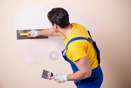 在墙上涂石膏的年轻承包商雇员泥水匠石膏板工具劳动者工作房子天花板水泥男人建筑图片