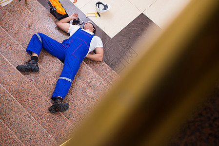 死承包商工人从楼梯上摔下来维修职业梯子男人赔偿工作头盔员工伤害办公室图片