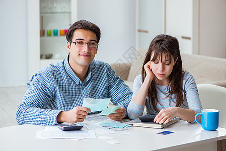查看家庭财务文件的年轻夫妇计算经济计算器赤字微笑婚礼夫妻花费预算妻子图片