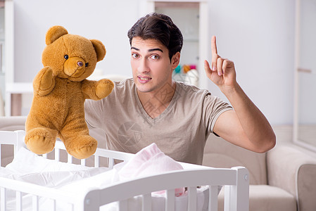 年青父亲在家与新生婴儿共度时光爸爸动物玩具父母房间关系男生女儿母性幸福图片