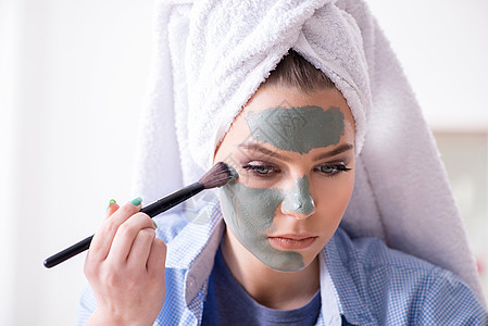 妇女在家里用带刷刷子的粘土面具剥皮女孩化妆师皮肤清洁治疗按摩呵护清洁剂美容图片