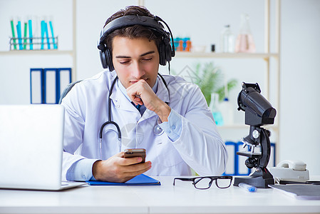 男性医生在远程医疗治疗期间听病人的男医生电话手机医院临床卫生短信保健笔记本热线治疗师图片