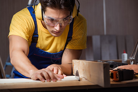 木工概念修补车间的工人工作人耳机工匠工作木板噪音木地板装潢承包商男人作坊图片