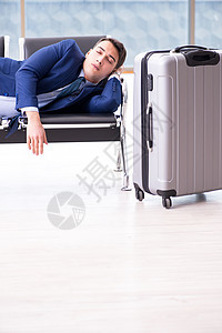 商务人士在机场等着他的飞机 在商业圈里等他航空公司睡眠男人套装房间行李飞行大厅管理人员旅行图片