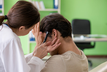 在体检期间检查病人耳部的女医生 女医生男人耳镜检查访问耳科耳镜耳朵咨询诊断感染测试图片