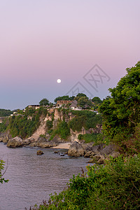 印度尼西亚巴厘岛巴兰甘海滩的魔术日落海浪旅行珊瑚支撑橙子晴天热带悬崖岩石房子图片