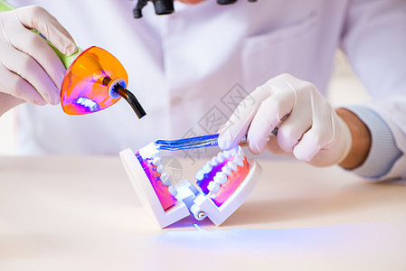 工作在牙科医院的年轻牙医衰变养护空腔治愈乐器关心程序卫生牙科医生牙科学图片