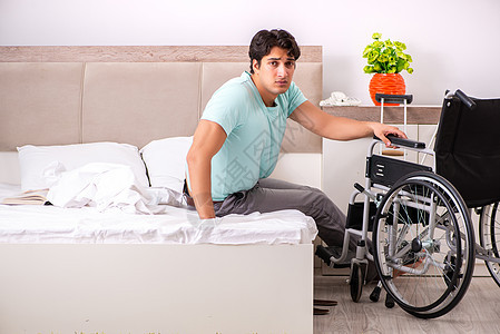 在家康复的年轻英俊残疾男子车轮轮椅房子卫生房间卧室残障创伤拐杖挫折图片