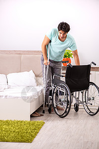 在家康复的年轻英俊残疾男子残障保健病人创伤男人人士痛苦假期卧室拐杖图片
