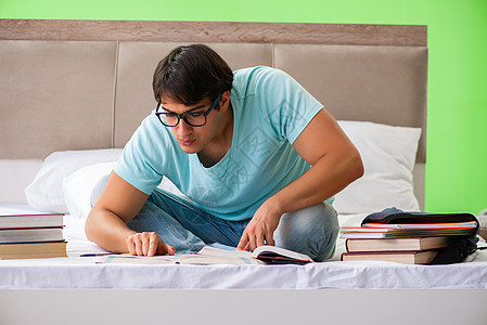 学生们准备在家的卧室里参加考试 坐在床上科学图书学校教育训练男人阅读学习教科书民众图片