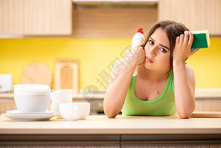 女青年在厨房打扫和洗碗女性泡沫龙头用具洗碗机工作主妇餐具房子盘子图片