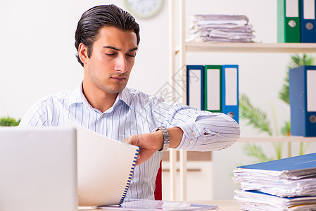 坐在办公室的年轻雇员工人管理人员工作文书报告职场桌子学生会计时间图片