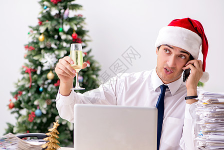 圣诞轮班在办公室工作的年轻工人桌子玻璃假期商务电脑商业审核干杯人士手机图片