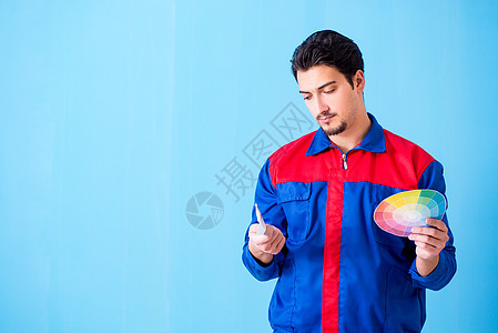 从彩虹中选择颜色的年轻男子承包商工作公寓蓝色思维修理工装潢画家建设者维修服务图片