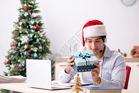 圣诞节期间通过电话销售的电视售卖运营商笔记本中心经理工人商业乐趣帽子桌子礼物员工图片