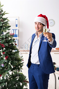 年轻雇员在工作场所庆祝圣诞节的年青雇员商业派对装潢饮料人士假期礼物帽子乐趣办公室图片