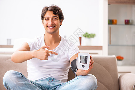 在家里测量血压的年轻人房子微笑测试男人动脉保险有氧运动保健脉冲高血压图片