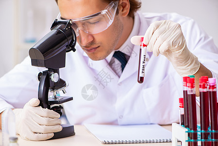 年轻英俊的实验室助理 在医院验血样本男人抗生素收藏感染血液学家生物玻璃疫苗化学品贮存图片