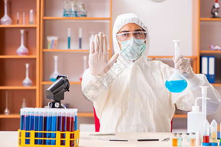 年轻生物化学家身着防护服 在实验室工作警告医生生物学药理科学家制药学生解决方案细菌显微镜图片