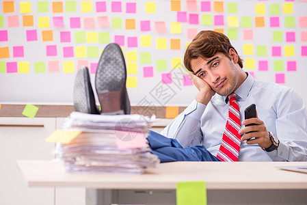 具有相互冲突的优先事项概念的英俊男青年员工电话平衡职业日程商务电脑男人文书办公室图片