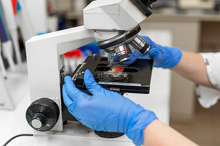 封闭实验室技术员在显微镜中研究血液样本实验化学品技术卫生临床药店医院生物学考试工作图片