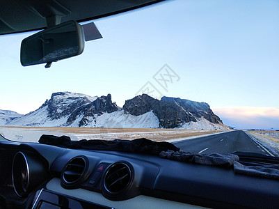 路上驾驶的一辆车所显示的山地景观图片