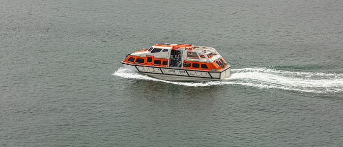 橙白救生艇在水中飞速移动图片