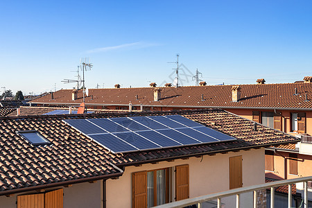 红色屋顶上的太阳能电池板房子蓝色天空太阳能板晴天建筑生态住宅经济技术图片