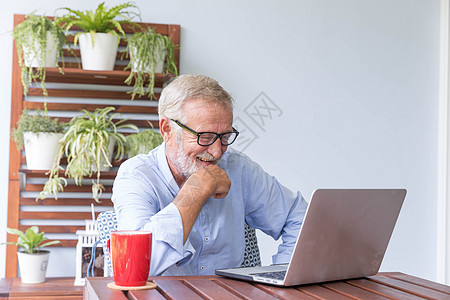 退休老人喜欢跟人闲聊 用自己的拉拉聊天工作互联网木头老年商业电脑笔记本闲暇冲浪桌子图片