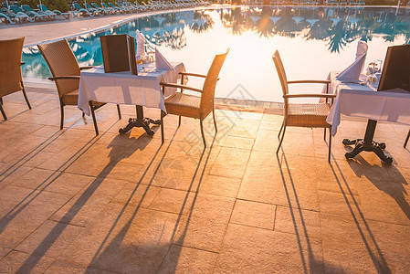 酒店餐厅桌椅和桌靠近游泳池咖啡店太阳椅子旅行白色水池奢华日落旅游木头图片