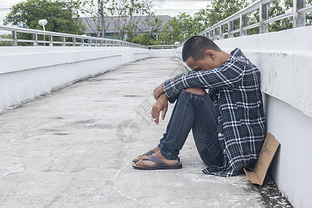 坐在天桥上的无助的流浪汉失业人行道城市男人成人杯子寂寞乞丐难民帮助图片