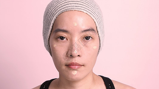 美丽的亚洲女性美容脸 用液态打成的艺术家褐色液体治疗皮肤化妆品粉末刷子海绵魅力图片