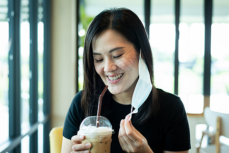 咖啡冰一位亚洲美女必须摘下蓝面罩和喝水衬衫咖啡咖啡店餐厅白色社会女士女孩头发黑色背景