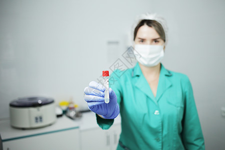一名身戴医疗面具的女护士持有验血试管医生预防女孩药品感染专家社工卫生医师诊所图片