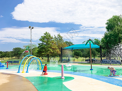 美国得克萨斯州达拉斯附近的喷水池里玩耍的 不同孩子在夏季图片