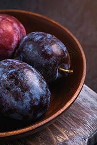 棕色木头碗中新鲜的甜梅子水果饮食乡村砧板紫色收成木板花园视角季节宏观图片