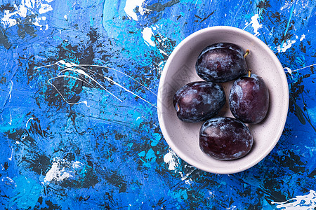 蓝底白碗中的新鲜甜李子水果空间营养饮食蓝色植物制品陶瓷收成盘子乡村图片