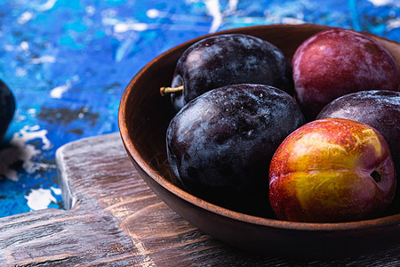 棕色木头碗中新鲜的甜梅子水果季节乡村花园砧板木板紫色视角盘子收成营养图片
