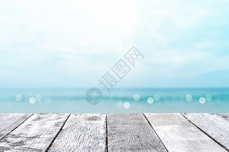 具有美丽海滩背景的旧木桌的精选焦点 用于展示您的产品桌子椰子海岸阳光海洋地平线旅游甲板海景晴天图片
