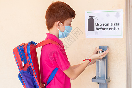儿童在进入教室前 先用手洗净剂使用医疗面具 即返回学校或重新开学的概念和冠状病毒或共生19号安全措施建筑肺炎教育背包课堂医疗书包图片