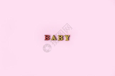 BABY 这个词是由浅粉色背景上的木制字母组成的 横幅设计 婴儿淋浴概念 最小背景的照片 装饰精美 文本位置与粉红色背景隔离孩子图片
