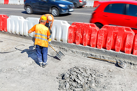 公路工人在修路期间击倒旧的混凝土 铲平一个工作区图片