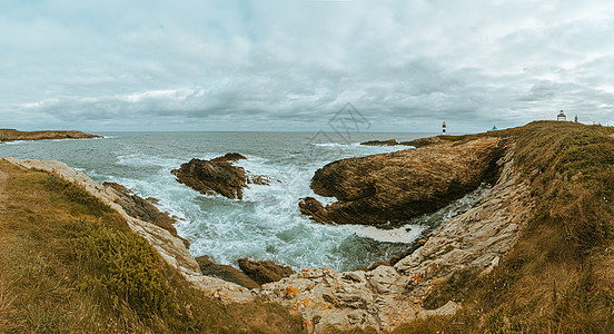 西班牙海岸的超广角镜头 一座灯塔靠近巨石 撞击海岸线 有复制空间图片