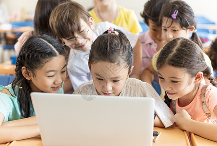 快乐的孩子在课堂上看笔记本电脑图片